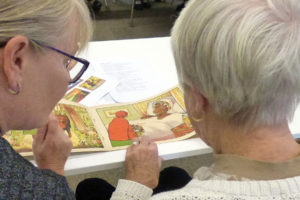 A colour image of two women looking at archives.