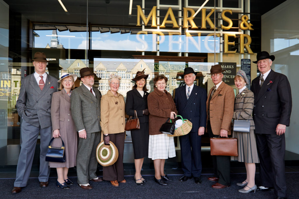 A colour image of a group of people in 1940s clothing.
