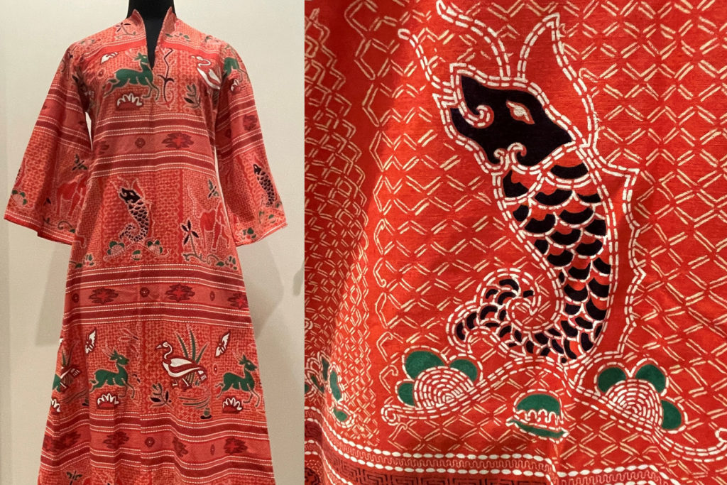 A colour image of a red kaftan dress with animal design.