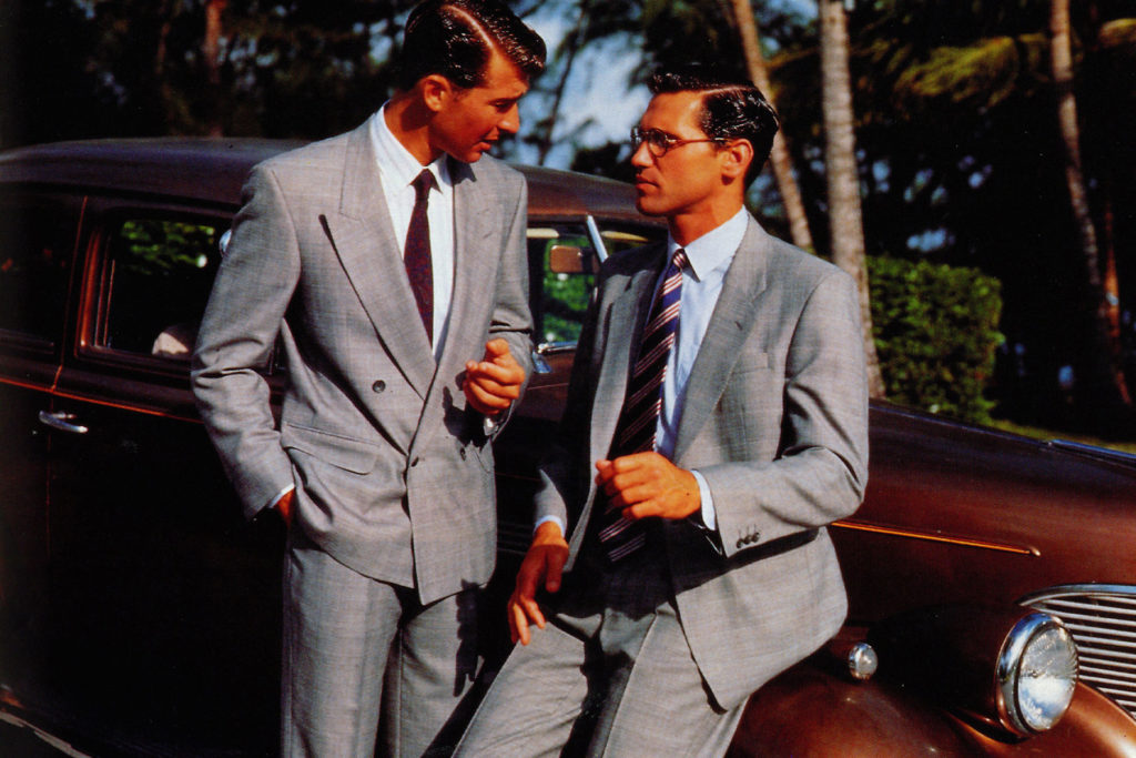 Colour image of two make models wearing grey double-breasted suits.
