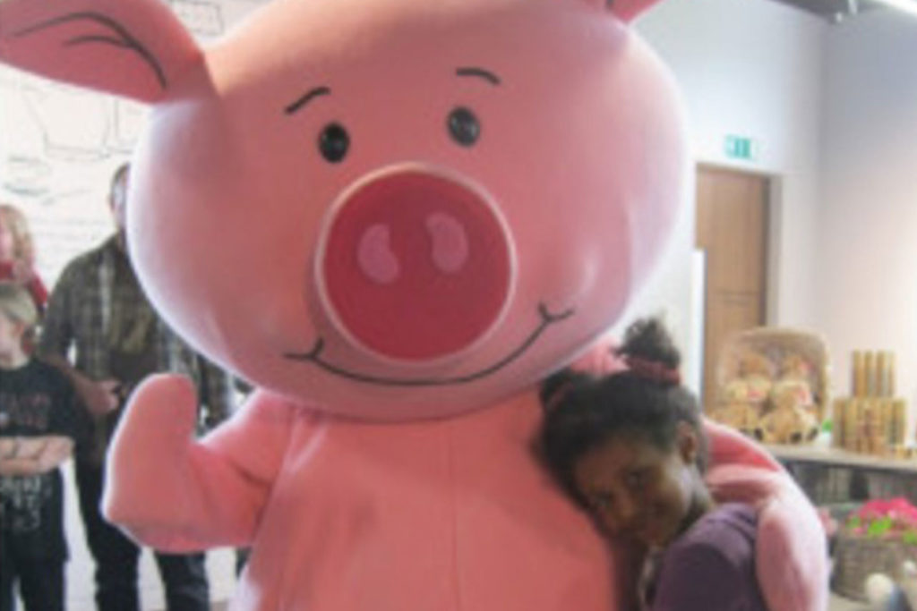 A colour image of a girl meeting Percy Pig.