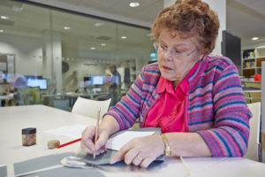 A colour image of a researcher at a table.