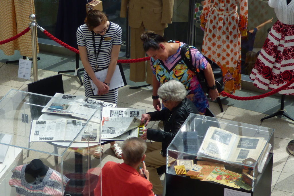 A colour image of people looking at archive material, taken from above.