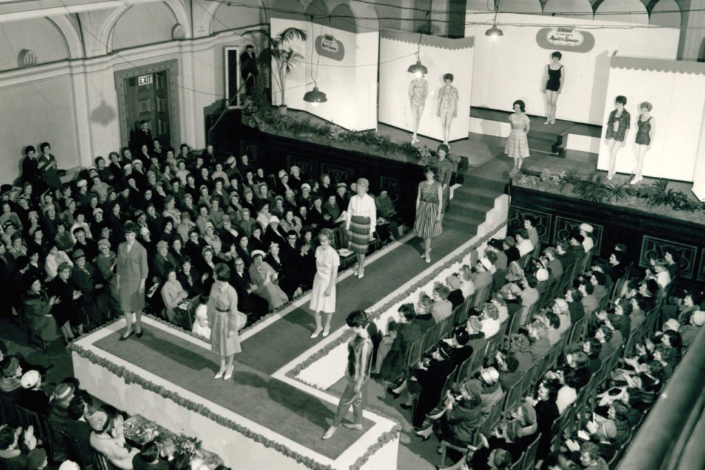 Black and white image of a catwalk fashion show from above