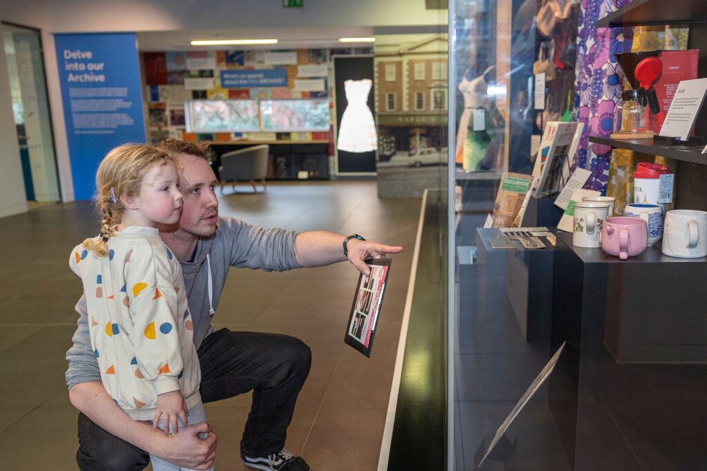 Colour image of a man and child looking at a display
