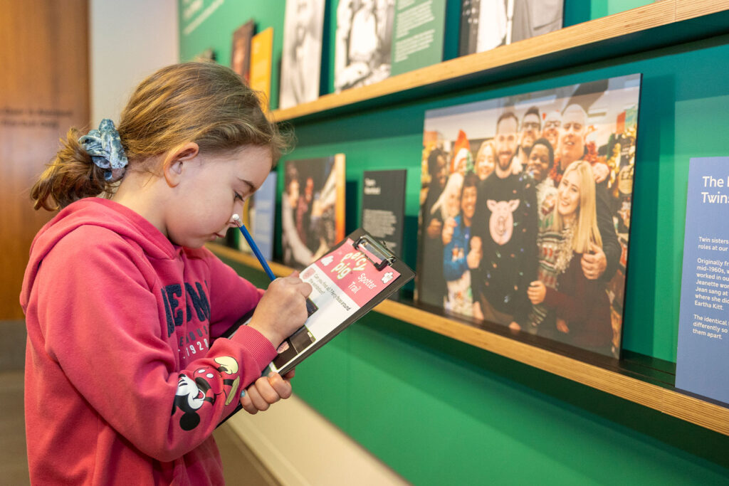 A girl looking at a clipboard and wall display