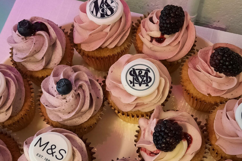 Colour image of cupcakes with pink icing and M&S logos