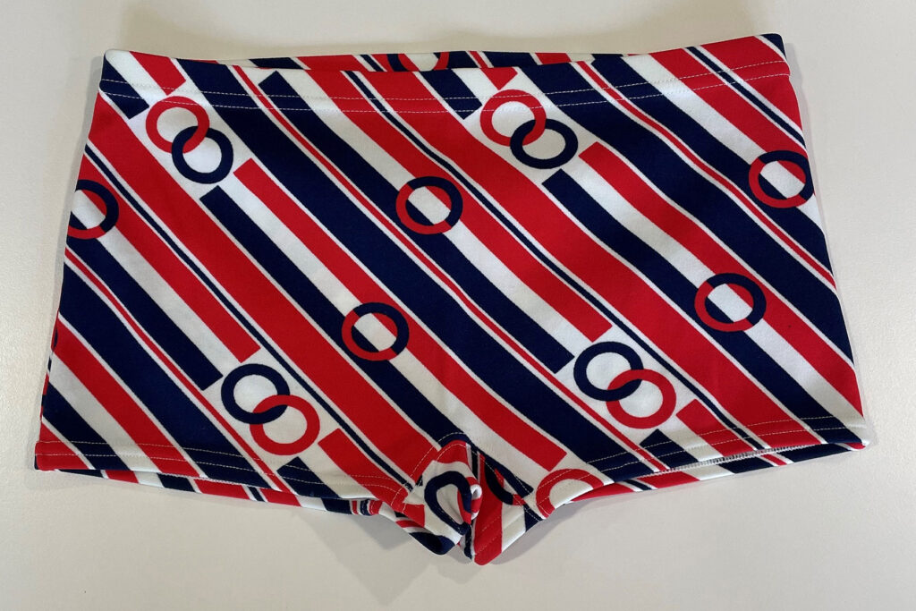 Colour image of a pair of boys' swimming trunks with red, white and blue pattern