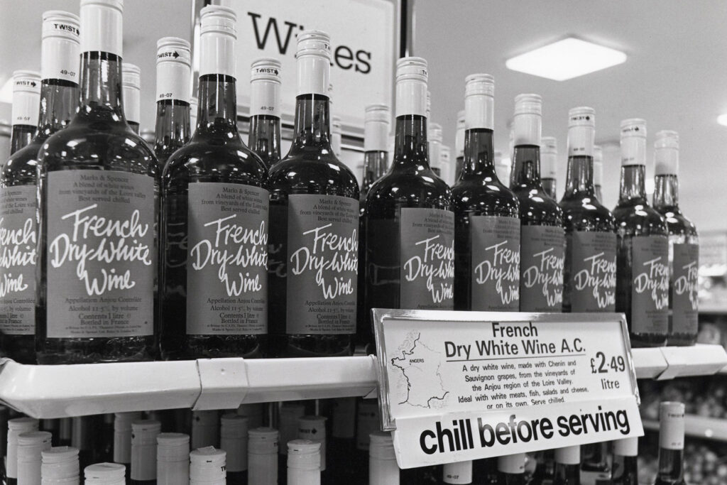 Black and white image of wine bottles on a shelf