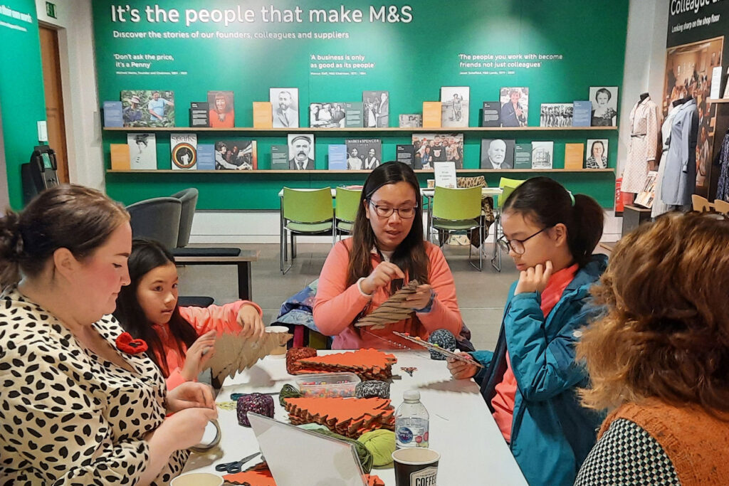 A colour image of a family doing a craft activity in a museum.