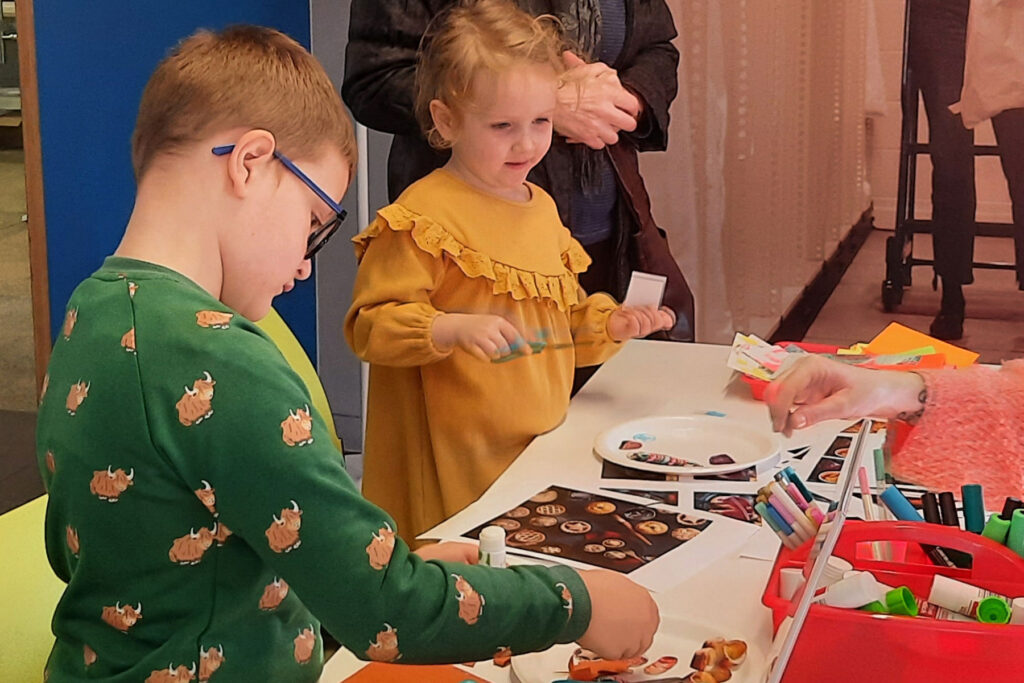 A colour image of two children doing a craft activity