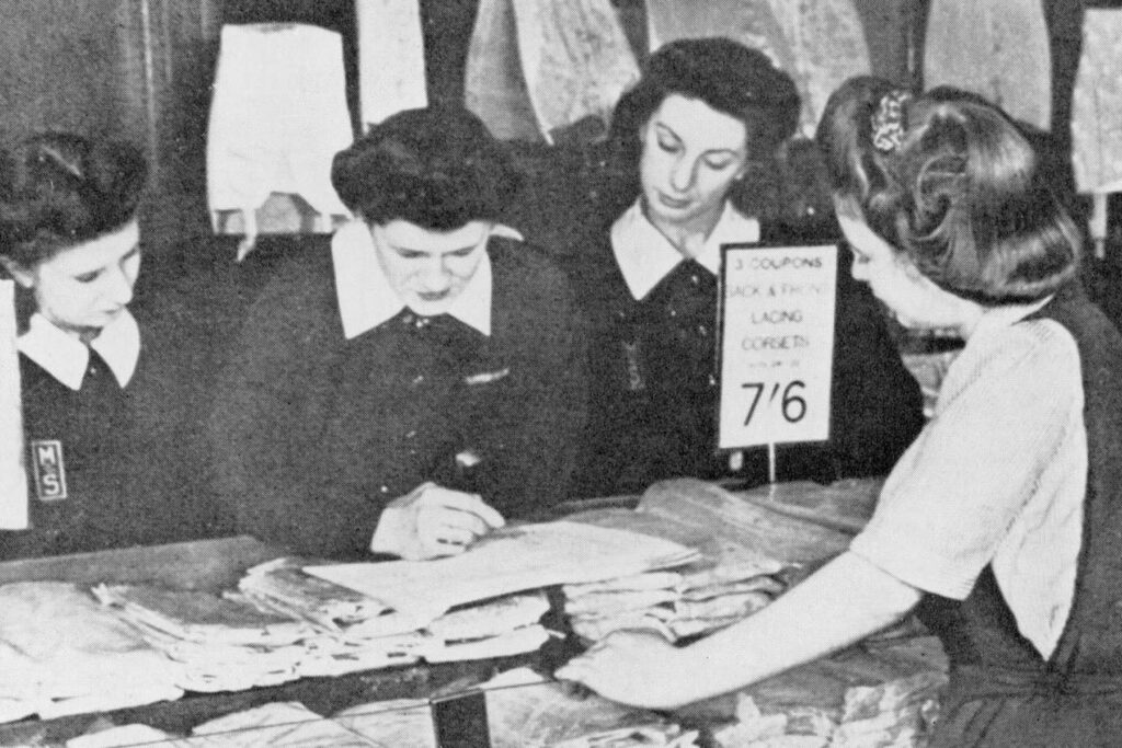 Black and white image of sales assistants at a counter